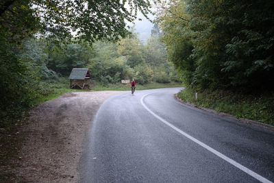 Front view of man cycling on road