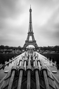 Black and white photo of the eiffel tower from the fountain of the place of trocadero in paris