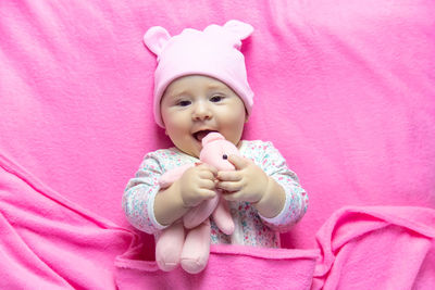 High angle view of cute baby girl with teddy bear