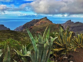 Scenic view of sea and mountains against sky