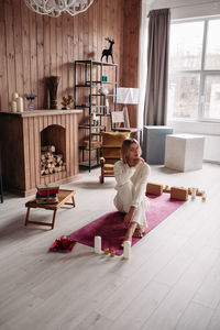 Woman sitting on wooden floor at home