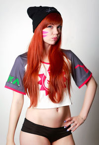 Portrait of beautiful young woman standing against white background