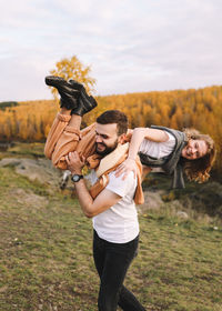 Happy people in love are travel hike in nature in the autumn forest. romantic trip to countryside