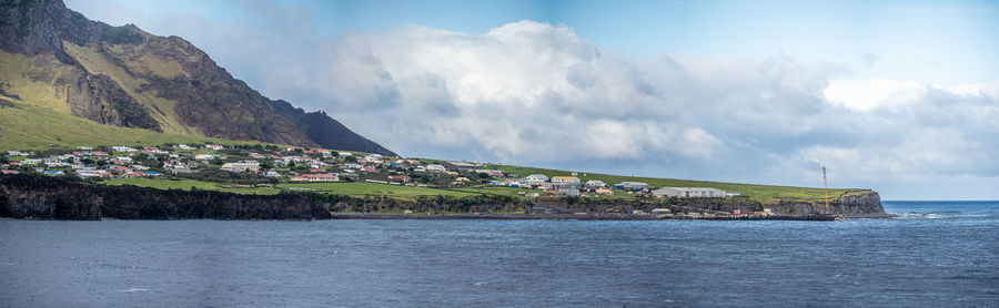 Scenic view of sea by buildings against sky