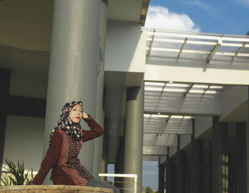 Low angle view of woman standing against building