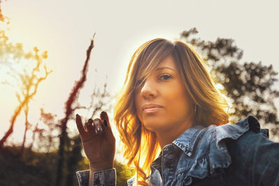 Portrait of beautiful woman against sky during sunset