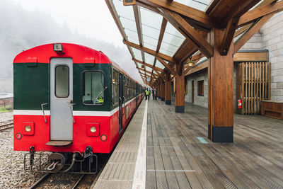 Red train at railroad station platform