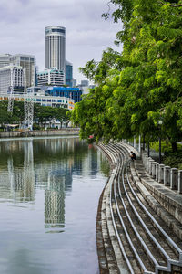 Bridge over canal by buildings in city against sky