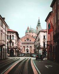 Road amidst buildings in city against sky