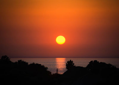 Scenic view of sea against romantic sky at sunset