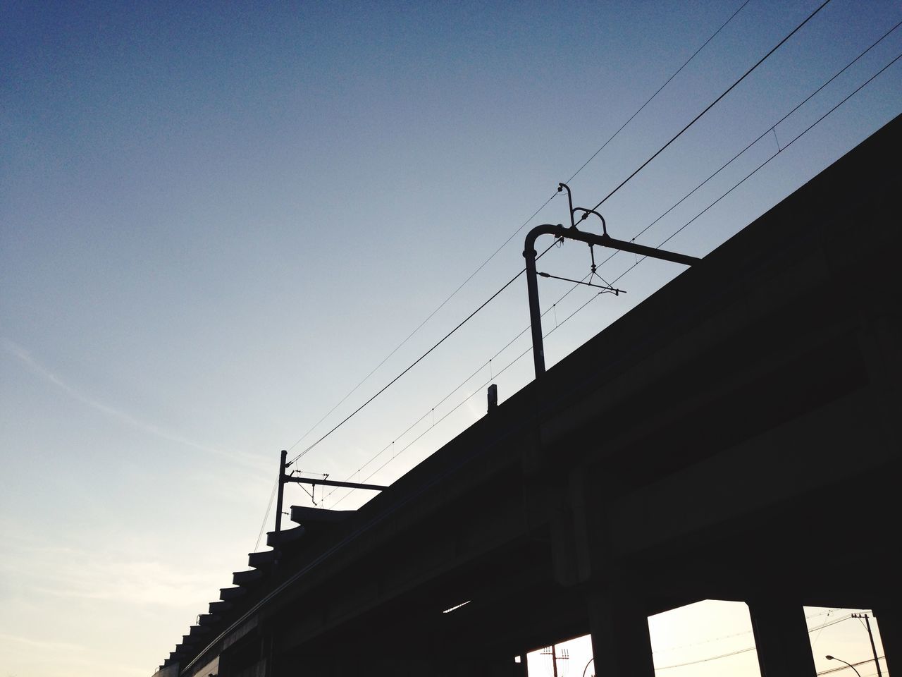 low angle view, architecture, built structure, building exterior, clear sky, silhouette, sky, connection, power line, building, copy space, cable, street light, high section, outdoors, blue, no people, day, dusk, city