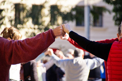 Midsection of people holding hands