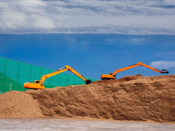 Pile of wood chips to storage for export by backhoe