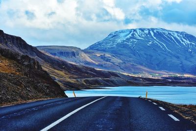 Road by mountains against sky