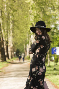 Portrait of a smiling young woman standing against trees