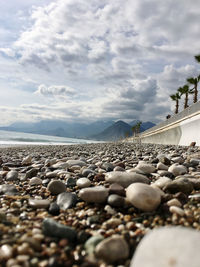 Surface level of stones on beach against sky