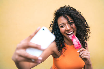 Portrait of smiling young woman using mobile phone