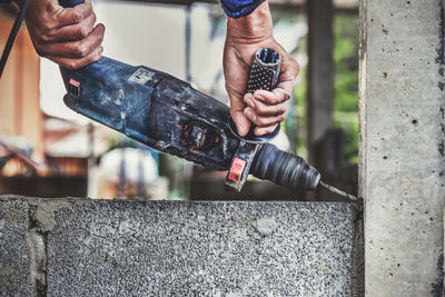 Midsection of man working on metal