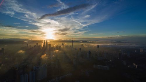 View of cityscape against cloudy sky