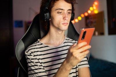 Man using mobile phone while sitting in darkroom