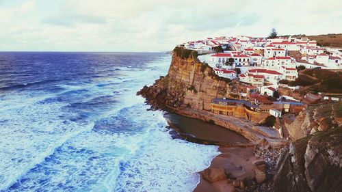 View of azenhas do mar on cliff by sea against sky