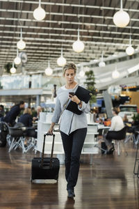 Businessman using smart phone while walking at airport