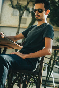 Full length of young man sitting on chair