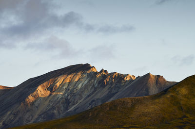 Majestic mountain ridge against cloudy sky