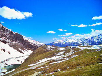 Scenic view of snowcapped mountains against blue sky