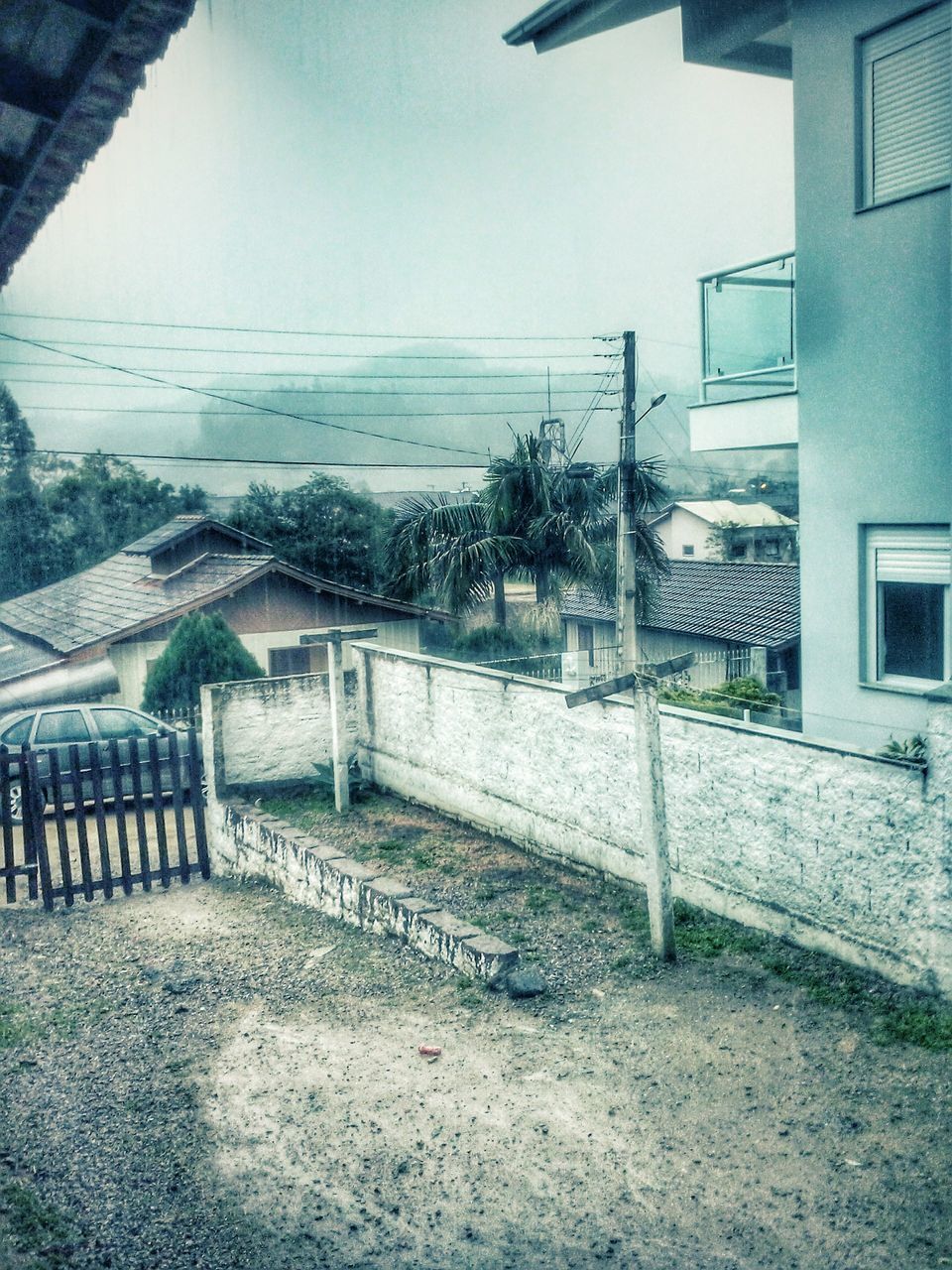 built structure, architecture, building exterior, railing, sky, day, no people, outdoors, connection, house, empty, water, sunlight, wall - building feature, absence, street, residential structure, fence, shadow, graffiti