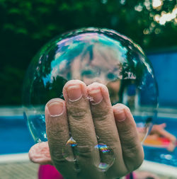 Close-up of person holding bubbles in water