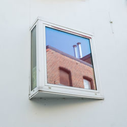 Low angle view of building reflection against clear sky