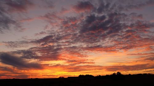 Scenic view of dramatic sky over silhouette landscape