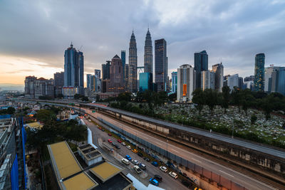 View of buildings in city against cloudy sky