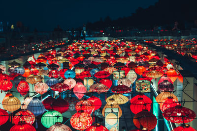 High angle view of illuminated multi coloured paper lanterns against sky at night 