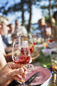 Hand holding wine glass with red wine