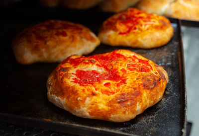 Mini pizza with tomato sauce baked in wood oven in bakery.