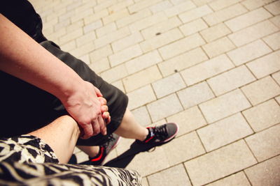 High angle view of homosexual couple holding hands while walking on footpath