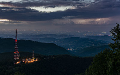 Scenic view of mountains against sky at night with storm and flash 