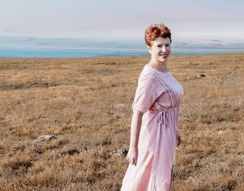 Woman standing on field against sky