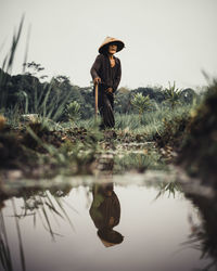 Rear view of woman with arms outstretched standing on field