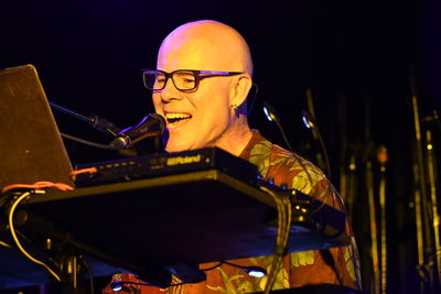 Portrait of happy man with illuminated lighting equipment at night