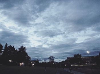 Silhouette trees against sky in city