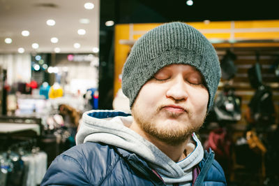 Close-up of man puckering while standing in clothing store