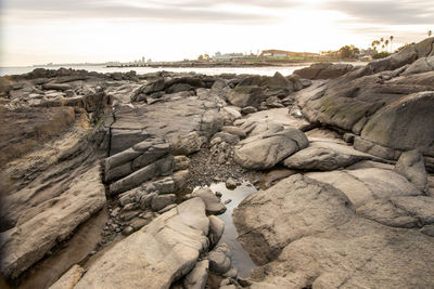 Rocks on beach against sky