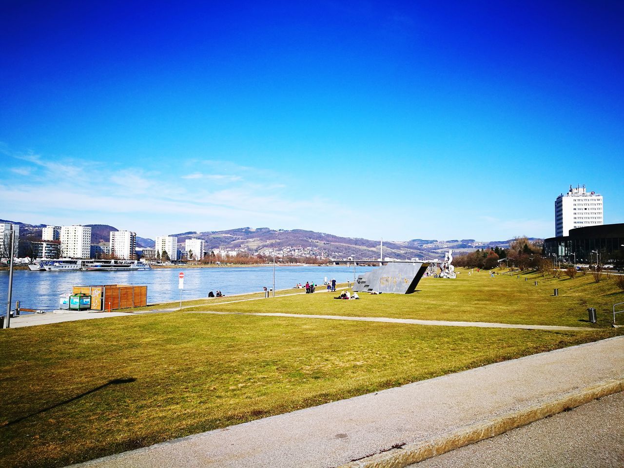 building exterior, blue, architecture, city, clear sky, built structure, sky, sea, cityscape, water, outdoors, real people, urban skyline, skyscraper, nature, modern, men, day, beach, beauty in nature, people