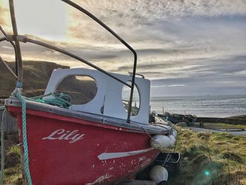 Close-up of ship moored at beach against sky