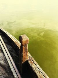 High angle view of rusty bollard on wood by lake