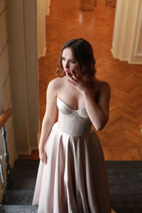 High angle view of beautiful woman wearing dress while standing on staircase