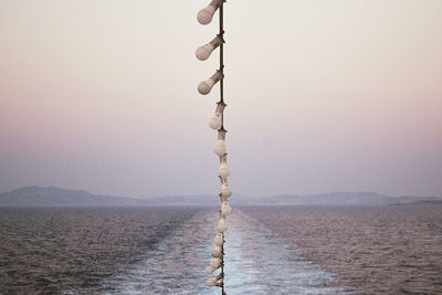 Close-up of rope on water against clear sky